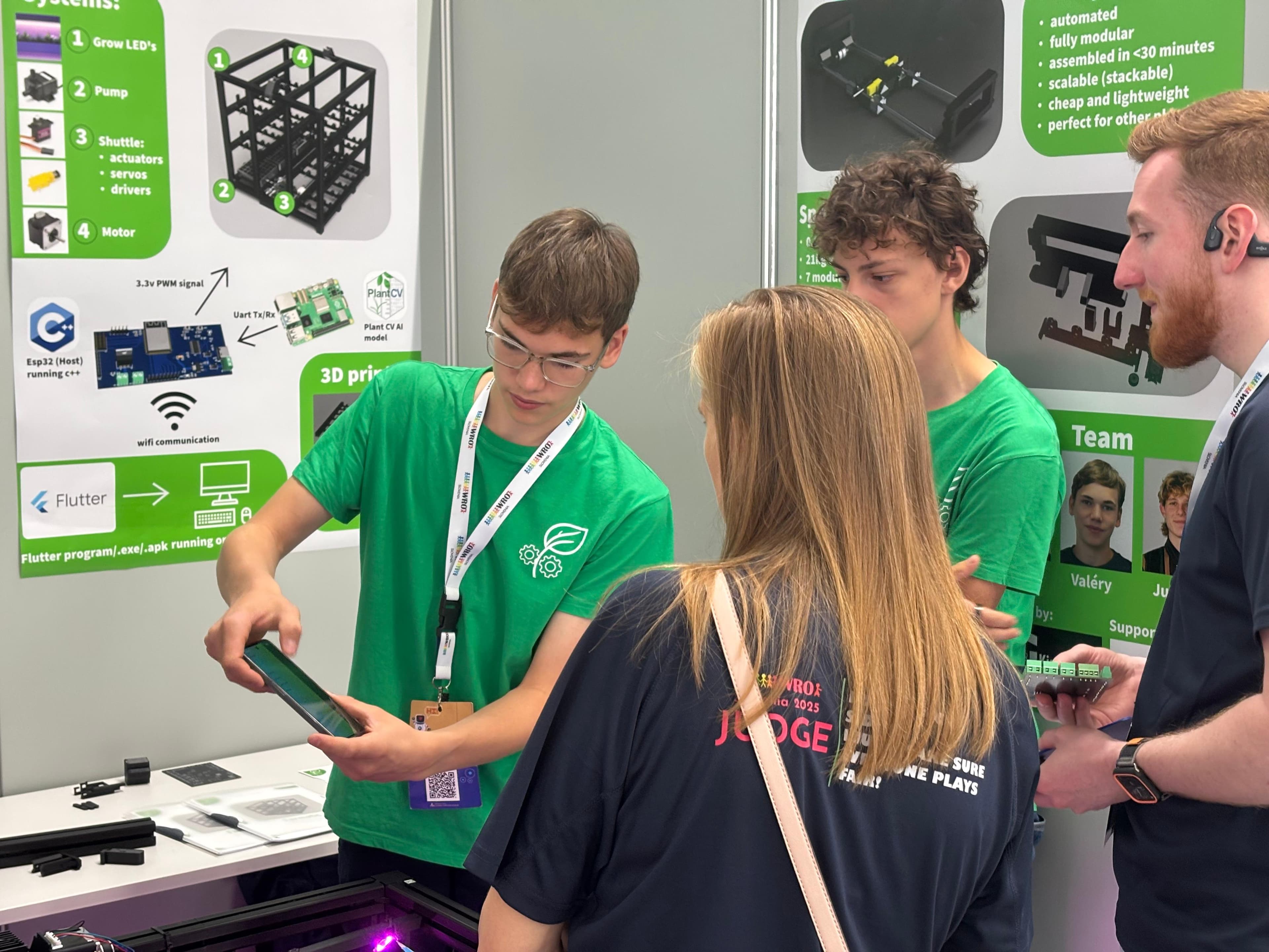 The team showing the Farmatic app to a judge at the World Robot Olympiad